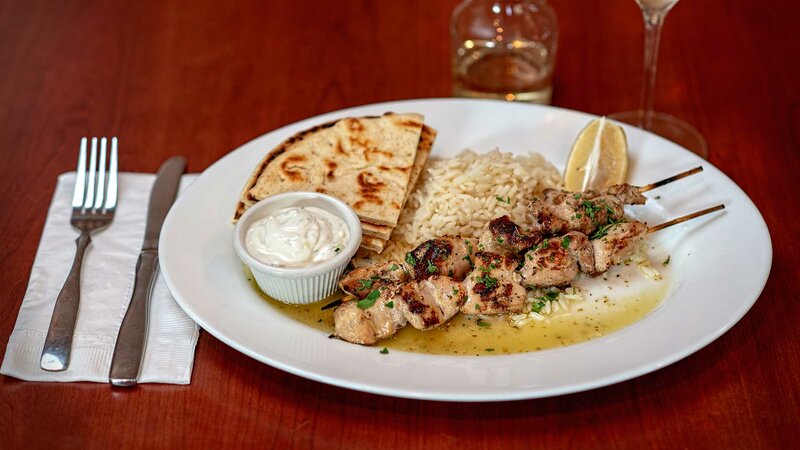 Skewered chicken with rice and pita