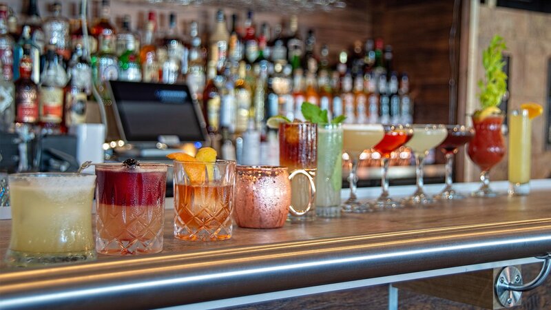 Multiple cocktails lined up on the bar top