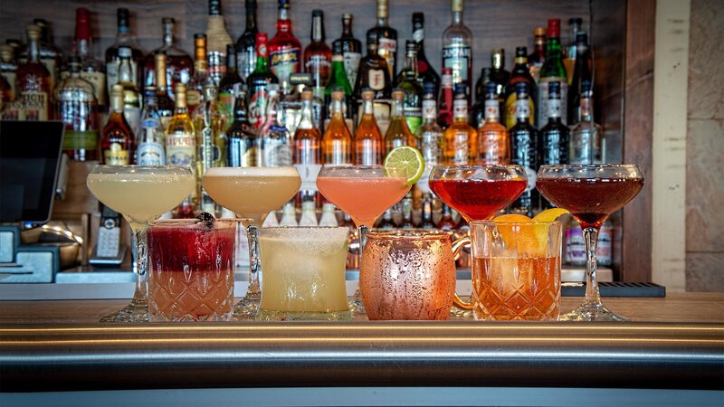 Multiple cocktails on bar top