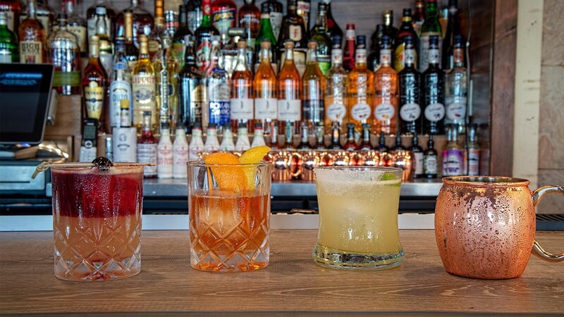 Four cocktails on bar top