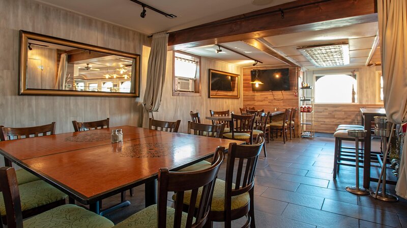 Interior dining area with view of table for six and two tables for four