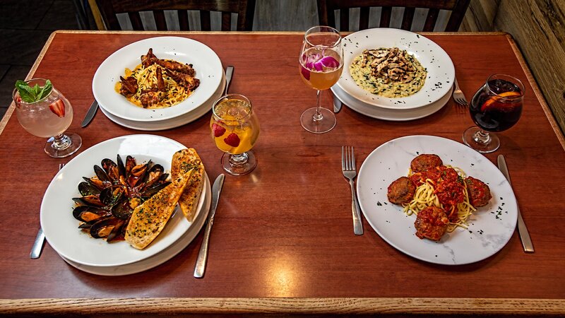 Plated mussels appetizer, meatballs appetizer, shrimp, and chicken entree