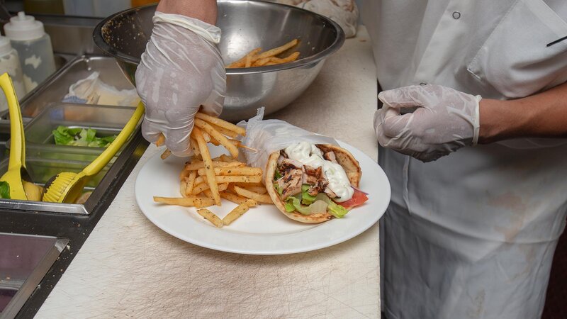 Kitchen staff preparing gyro platter